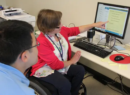 RHF Ambassador, Marika van Dommelen works with man on computer to close employment gap for people with disabilities