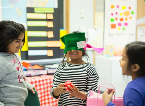 Child with blindfold surrounded by other children 