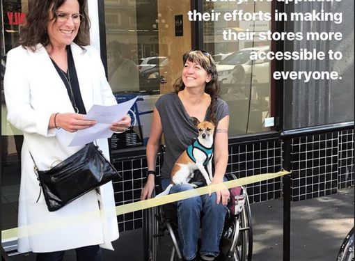 1 woman accompanied by a woman in wheelchair celebrating a ramp being built for accessibility at Starbucks. 