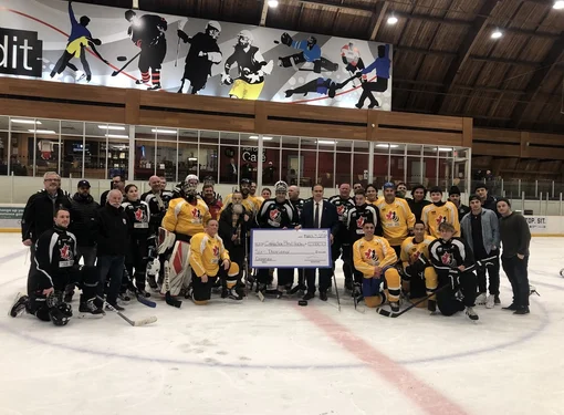 Hockey team posing on ice at rink.
