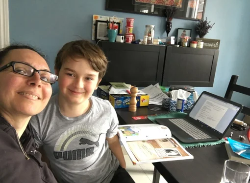 Marjorie and her son at a desk doing virtual learning 