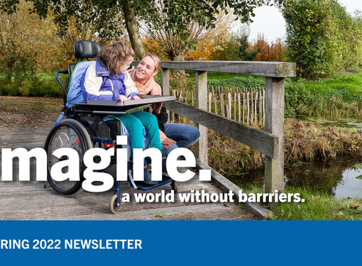 A girl in a wheelchair is looking at a woman kneeling beside her. They are on a wooden bridge. Imagine a world with our barriers is written in white. In a blue banner below, Spring 2022 Newsletter is written in white.