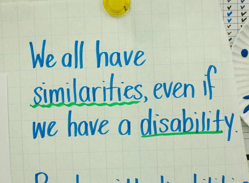 Blue ink on large paper that reads "We all have similarities, even if we have a disability." The words similarities and disability are underlined in green.