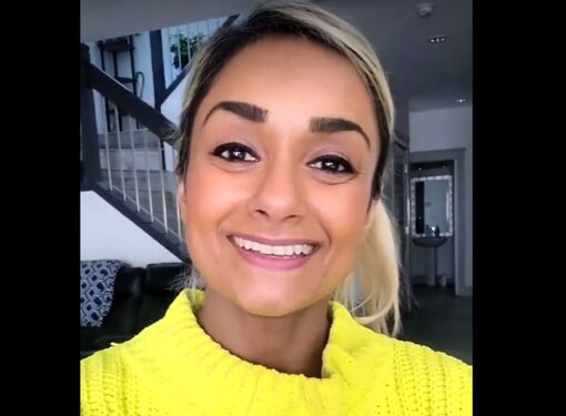 Bean Gill smiling wearing a yellow turtle neck sweater. 