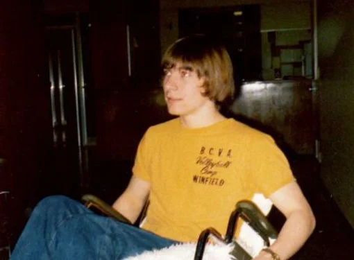 A teenage Rick Hansen popping a wheelie in his wheelchair.