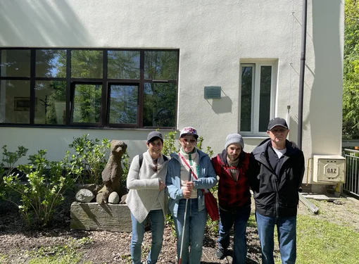Rachel Ganz and her family standing outside of a building. Rachel is holding a red and white cane.