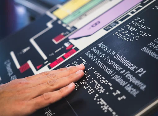 a close up of a hand touching braille signage