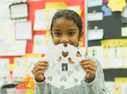 Elementary girl student participate in Abilities in motion school program snowflake activity