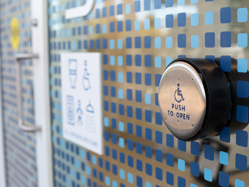 Accessible power door opener with text 'push to open', patterned background