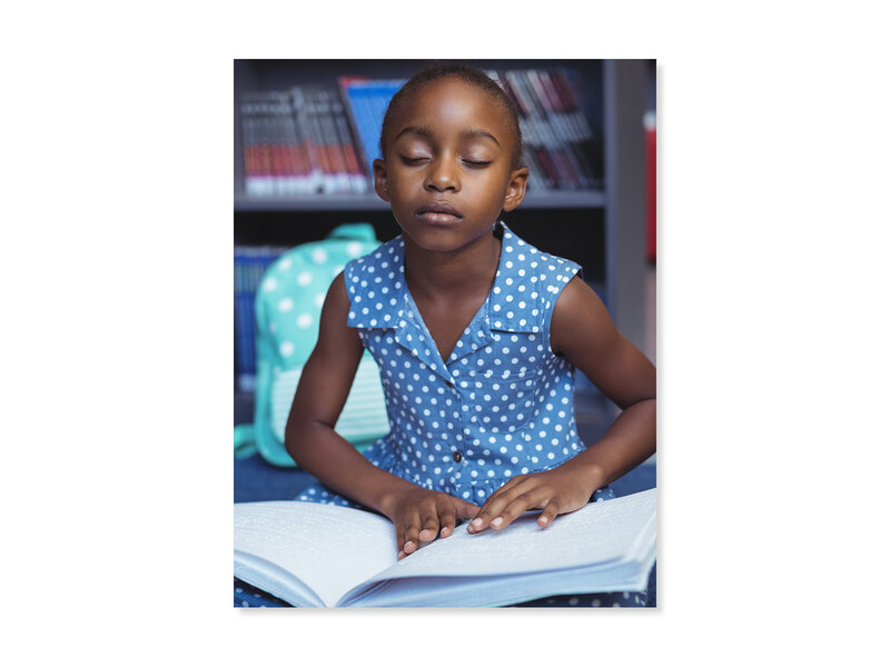 Une jeune étudiante lisant un livre en braille.