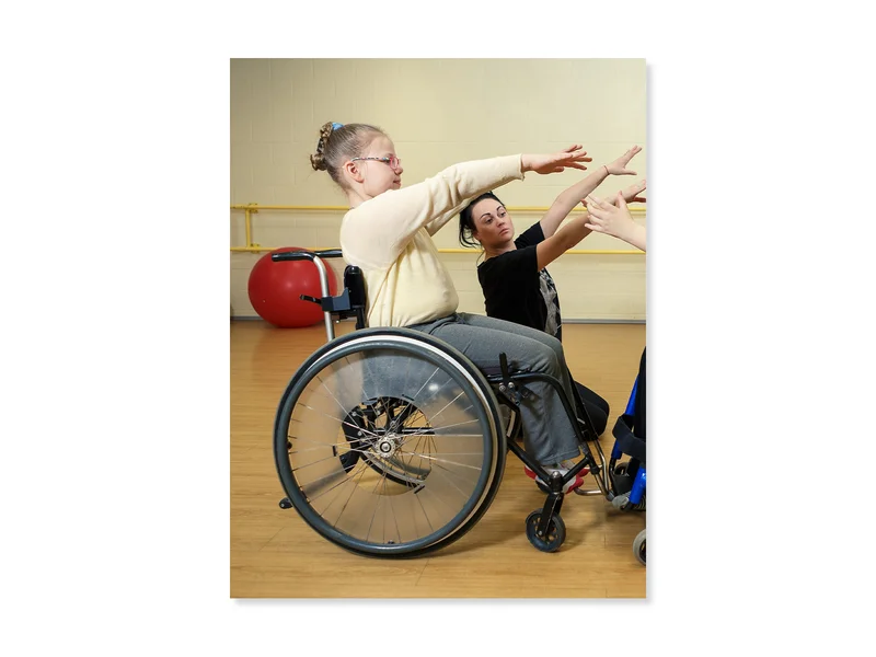 Elementary age student using a wheelchair, participates in an inclusive physical education class.