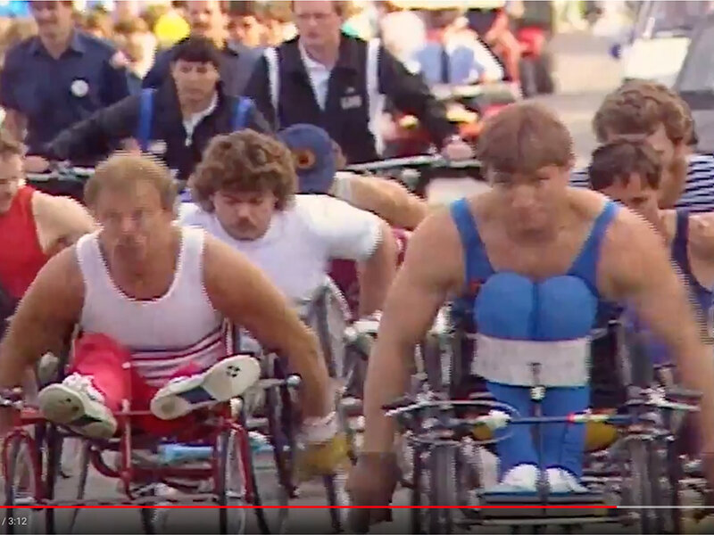 Des gens à fauteuil roulant accompagnent Rick Hansen pendant la Tournée mondiale Rick Hansen.