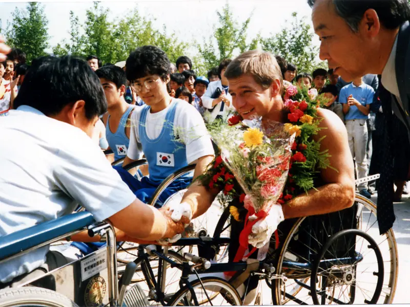Rick Hansen receiving flowers and a wreath and meeting with a Korean wheelchair basketball team at the city hall of Daegu, Korea on May 7, 1986.