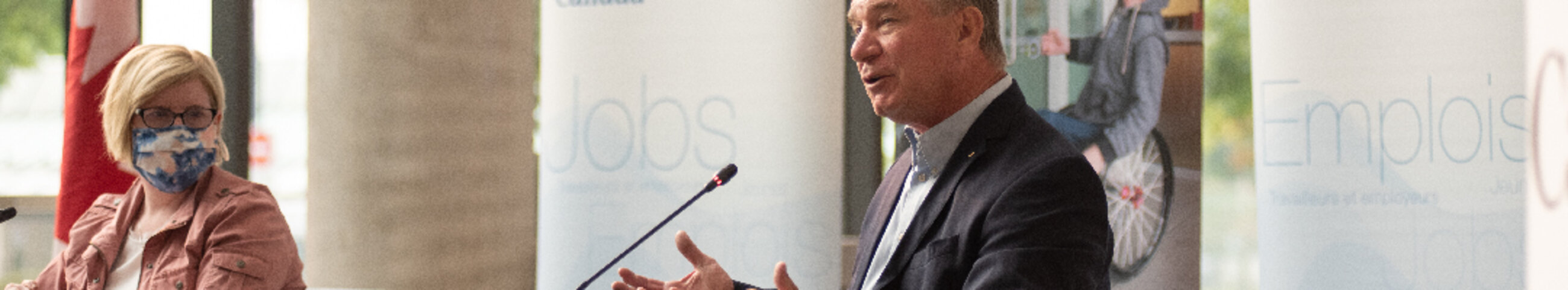 rick hansen speaks into a microphone