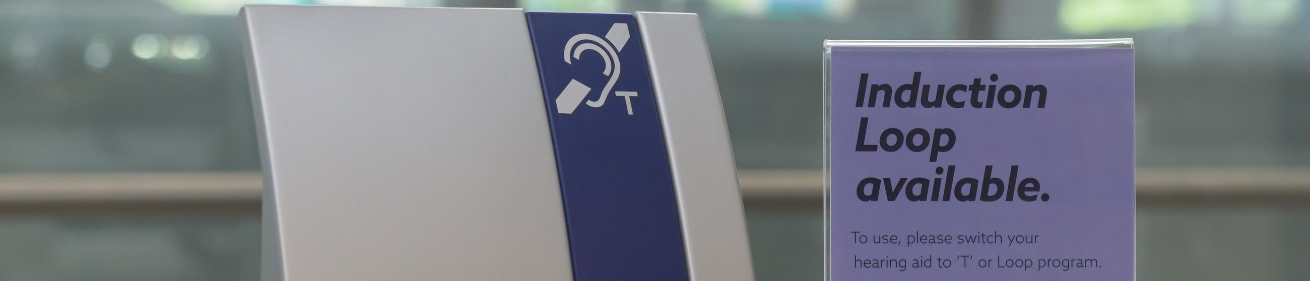 Sign with an ear and “T” symbol, next to text reading “Induction Loop available.”