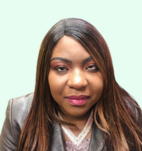 Laetitia Mfamobani, who has long brown hair and is wearing pink lipstick and eyeshadow. She is wearing a grey blazer and is against a mint green background.