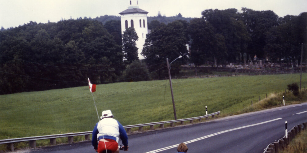 En août 1985, Rick Hansen s’approche d’une chapelle en Suède en compagnie de Lee Gibson.