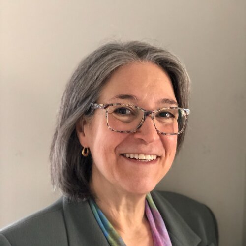 Woman wearing grey blazer and glasses