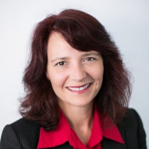 smiling woman with shoulder length brown hair and a professional red collared shirt on