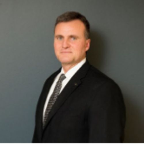 professional photo of a man with short brown hair, smiling, wearing a suit