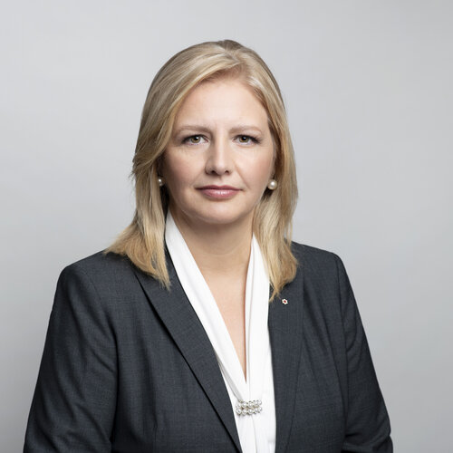 Headshot of Tamara Vrooman. She has shoulder length blonde hair and is swearing a dark suit jacket with a white shirt.