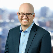 Headshot, man in suit and glasses, smiling