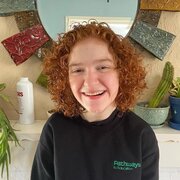 Young woman with short red hair smiling at the camera 